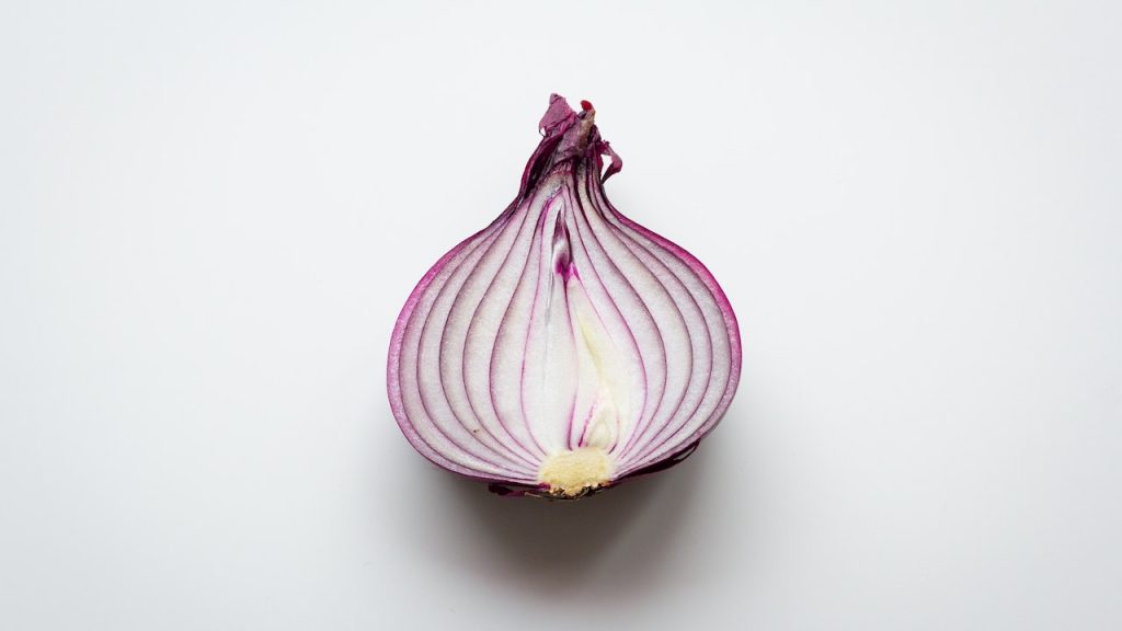 Half an red onion placed on a counter exposing its many layers.