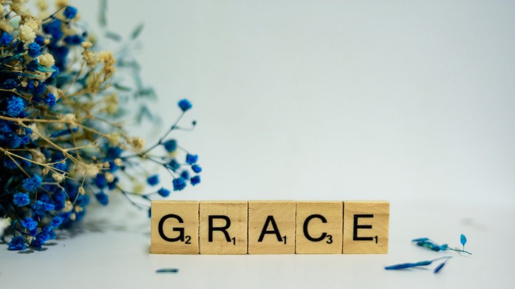 Wooden Scrabble tiles forming the word GRACE.