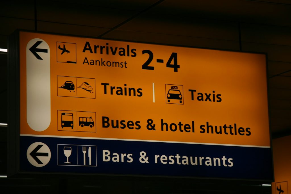 A sign in an airport with the words Arrivals and other information.