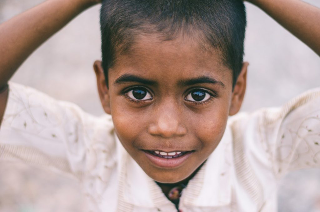 A young boy looking directly at the camera and smiling.