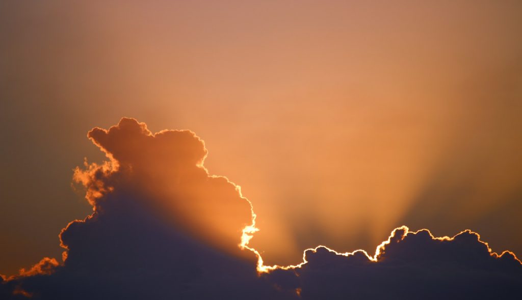 The silver lining at the edge of a cloud being illuminated by the sun from behind.