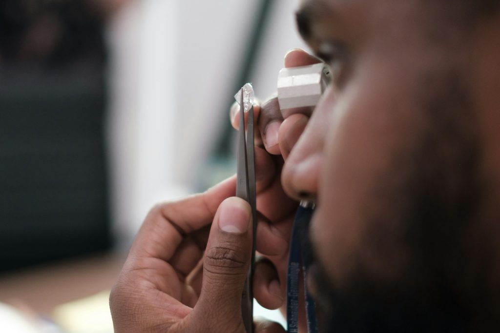 A man examines a diamond using an eyepiece.