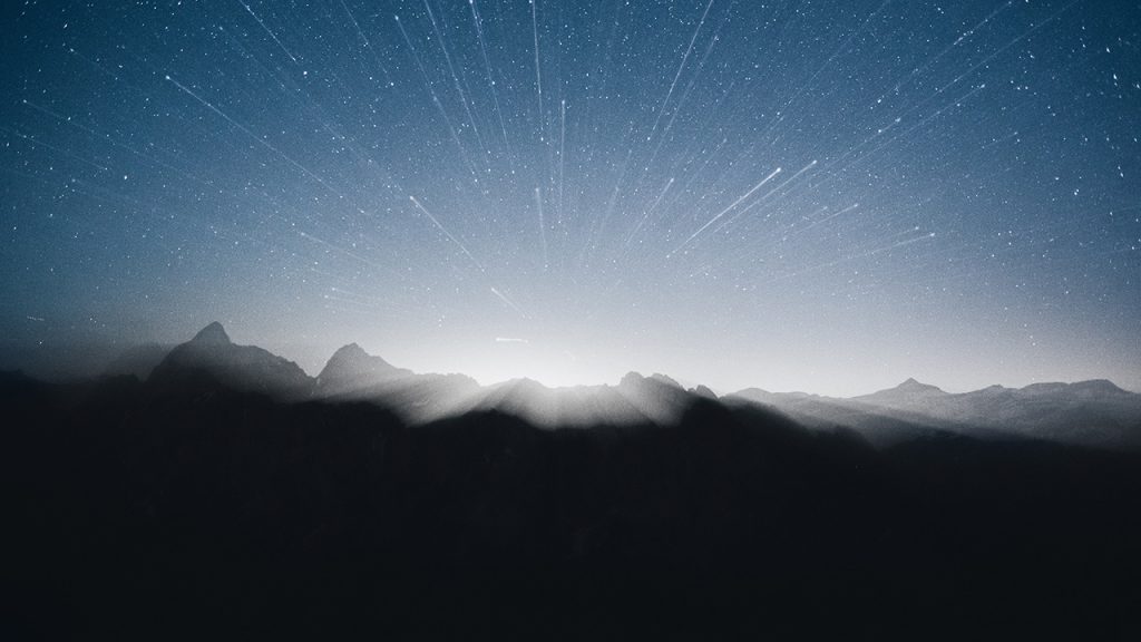 A radiant starfield over a mountain range at night.