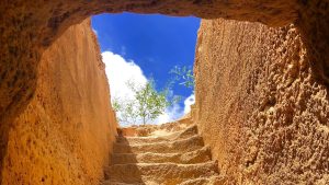 Stone steps leading out of a cave tomb into daylight.