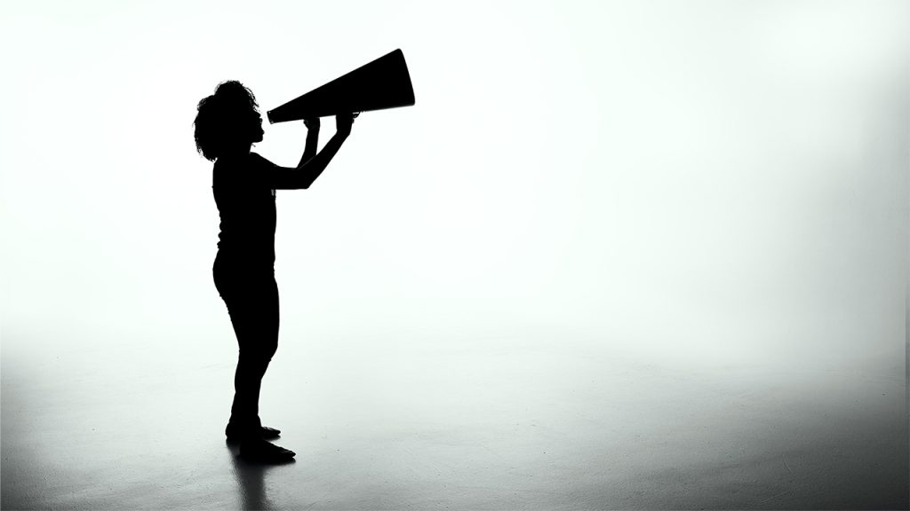 A silhouette of a woman shouting into a megaphone.