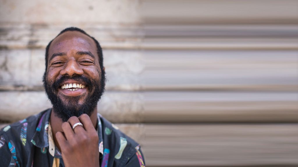 A very smiley man with a big bushy beard.