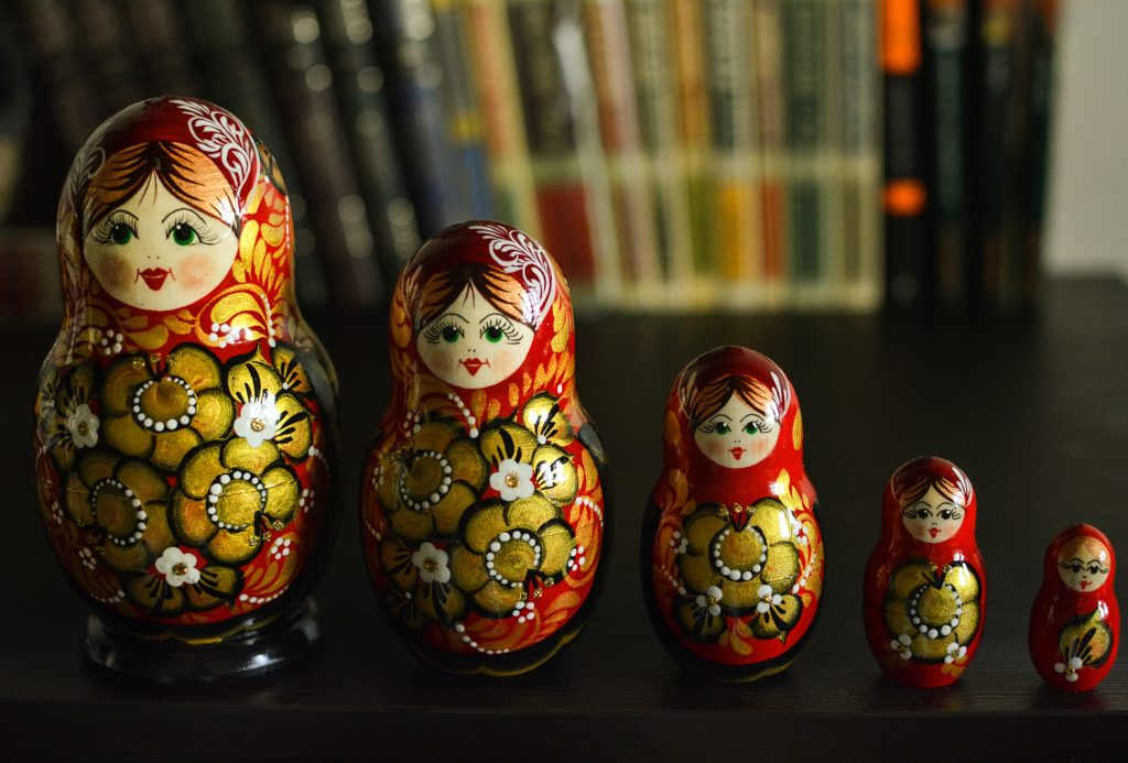 A series of wooden Russian Dolls standing next to each other.