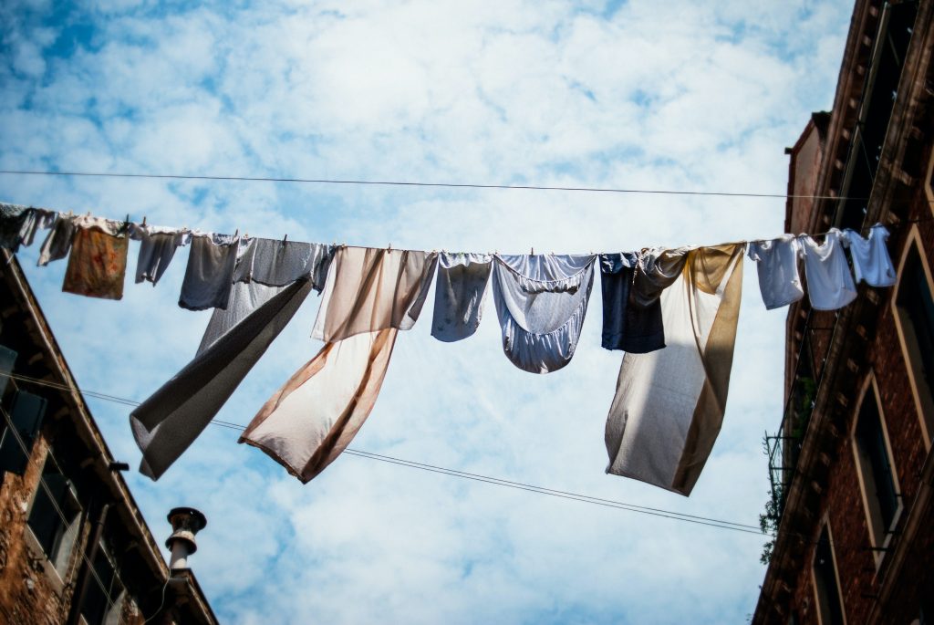 Washing hanging on a line between two buildings.