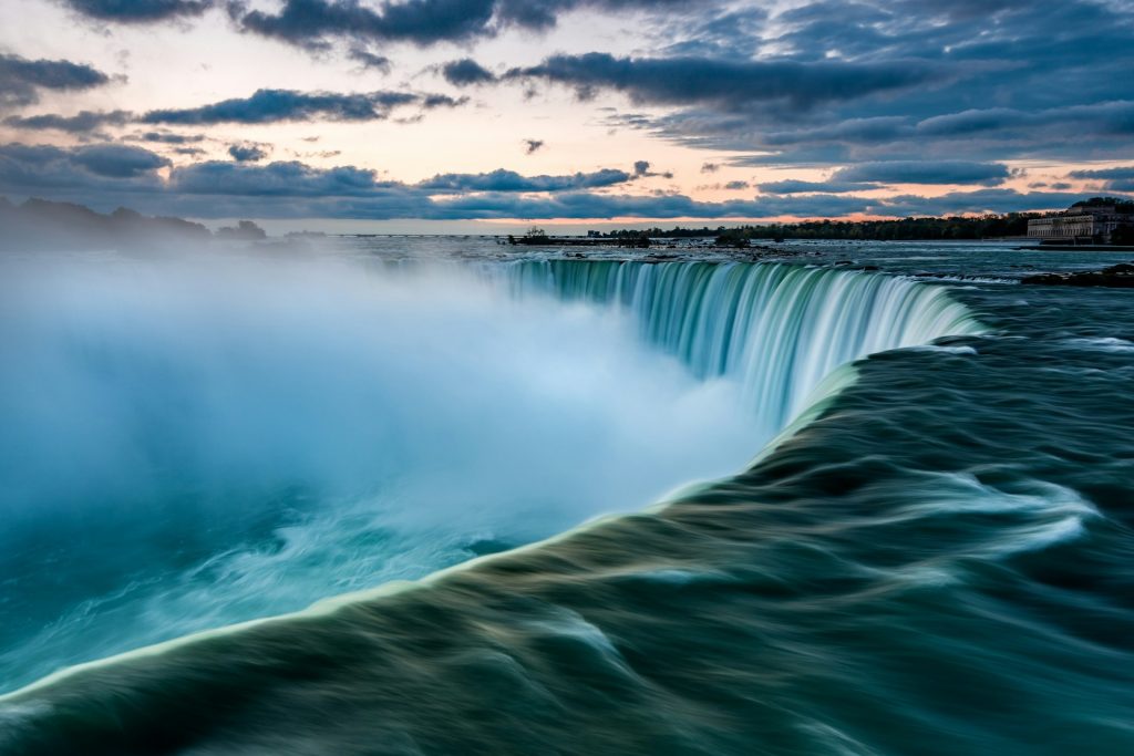 A huge waterfall with water vapour rising from the base of the falls.