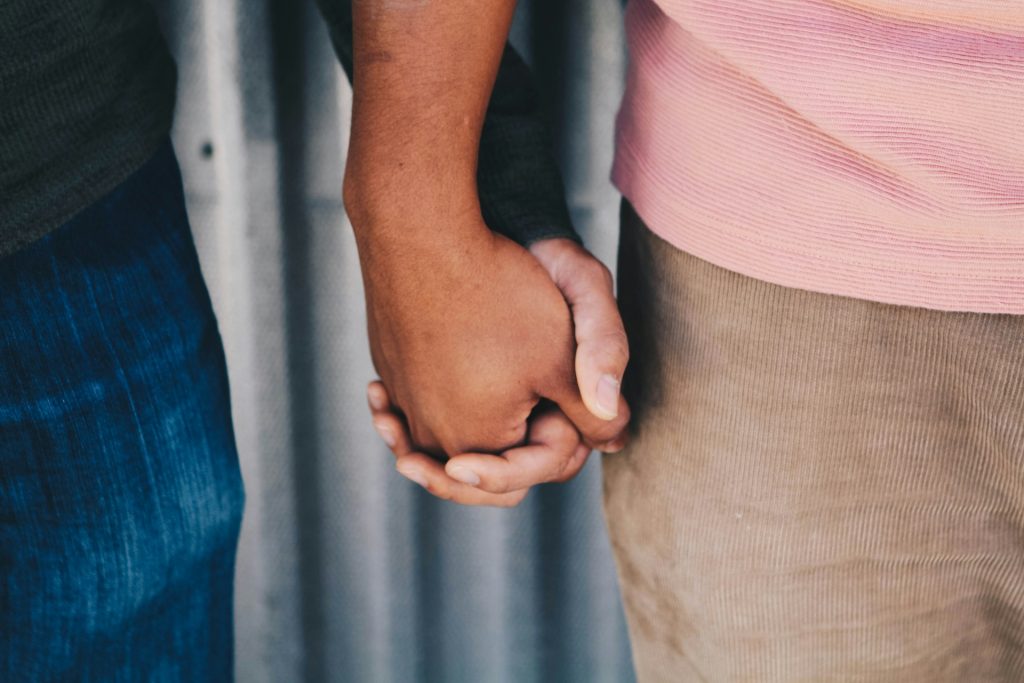 A close-up of the two men holding hands.