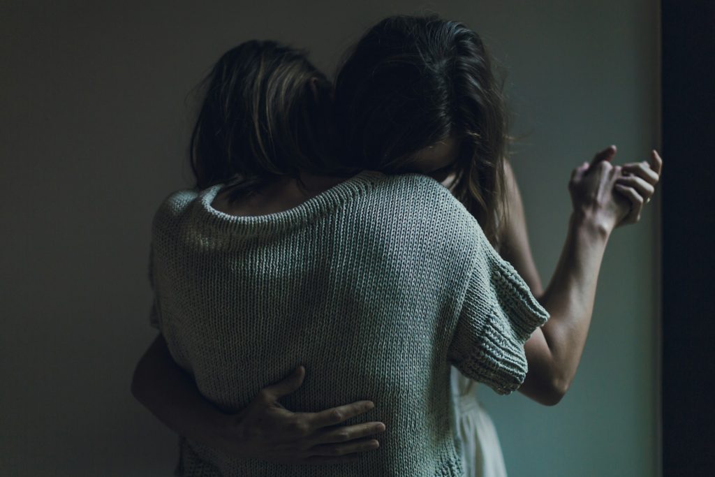 Two women hugging in an embrace.