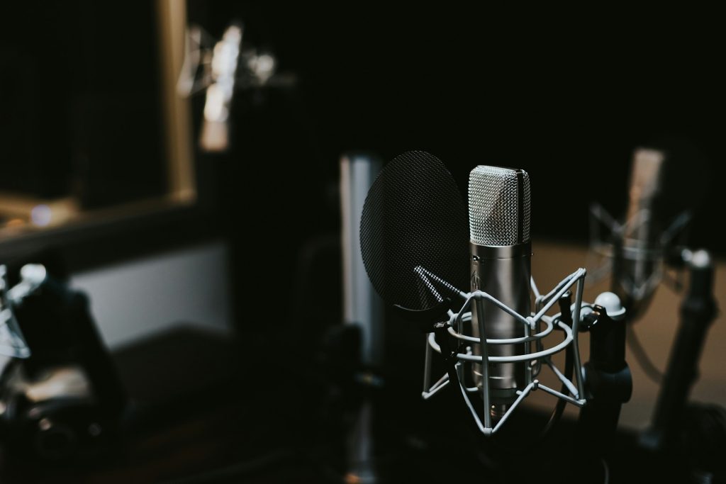 A microphone in a stand in a recording studio.