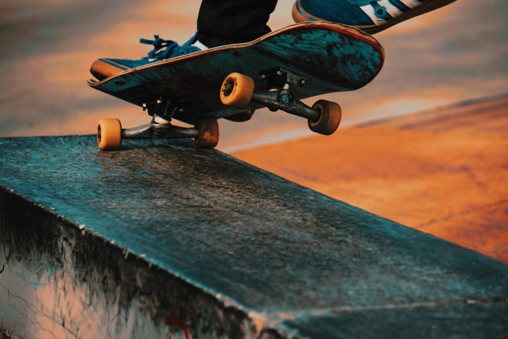 A person on a skateboard doing a trick by grinding along the edge of a wooden bench.