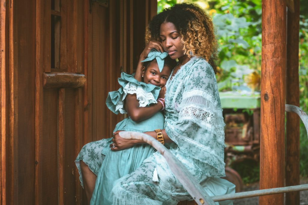 A woman holds her daughter in a loving embrace.