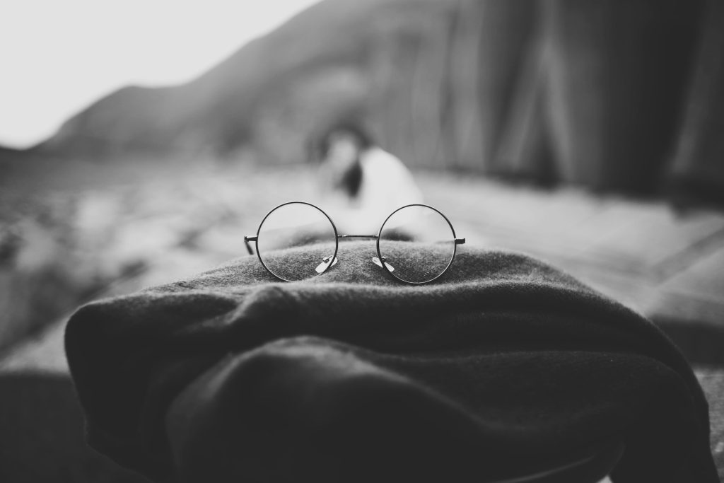 A pair of glasses resting on a blanket.