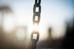 A chain where the sunlight glows on the chain so brightly it looks as if the chain has been broken, which it has.