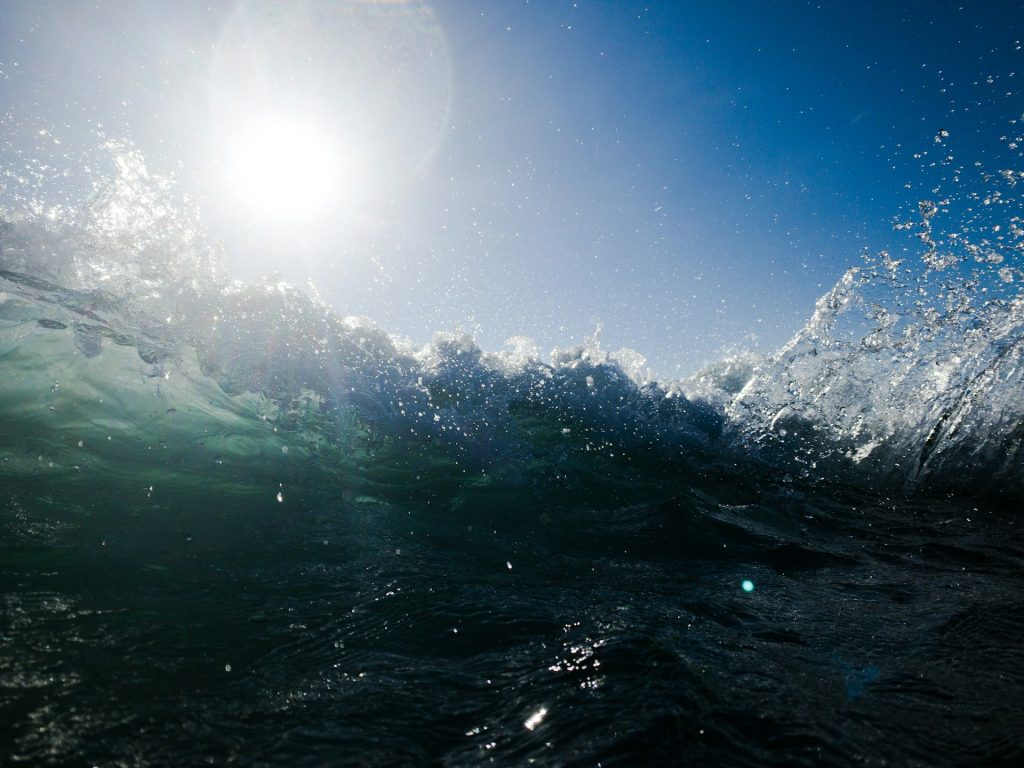 Wild waves crashing against the sunlight.