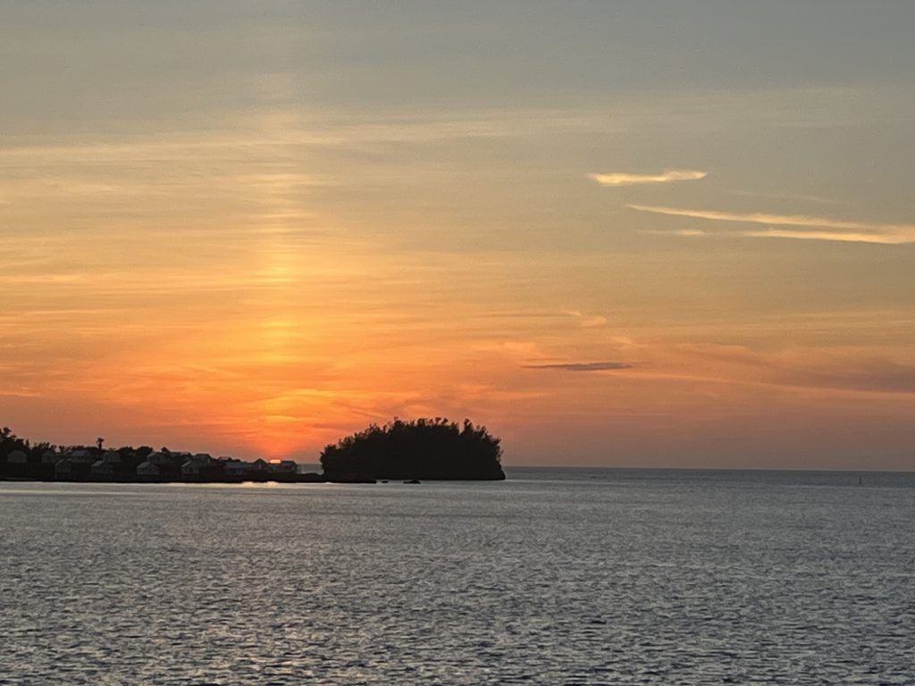 The sun setting behind an island.