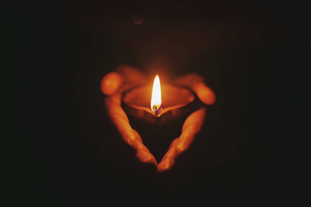 A picture of a single candle in cupped hands