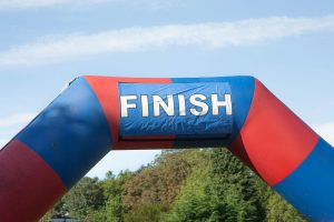 A brightly coloured inflatable finish line gateway - one of the types that you run underneath. It has the words FINISH in large white capitals printed on it.