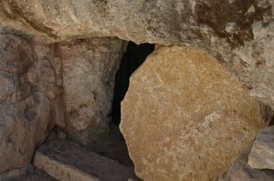A stone tomb with a large round rock that can be rolled away from the entrance.