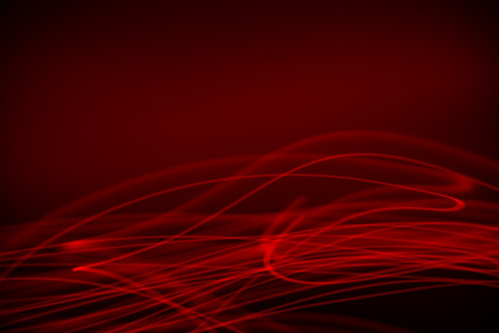 Blurry bright red light lines streak back and forth across a dark red background.