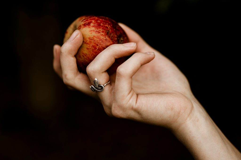 A woman holds an apple in her hand.