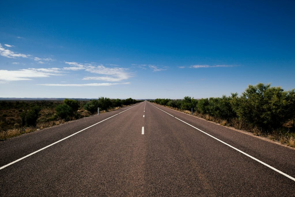 A road in the Australian outback stretches off into the distance.