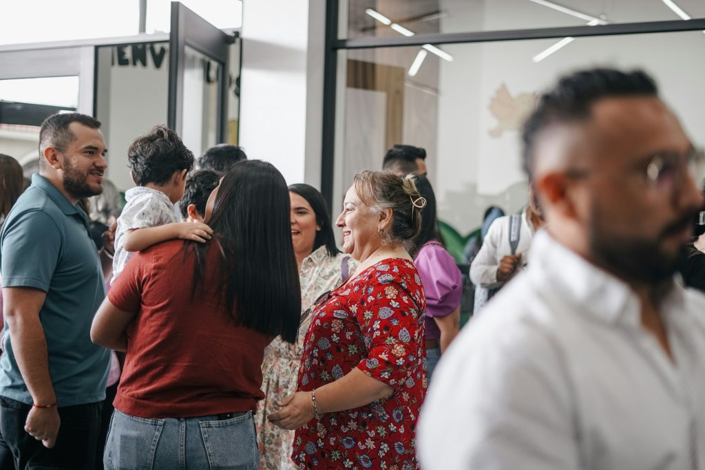 A church family gather in a hall after worship and it is wonderfully diverse.