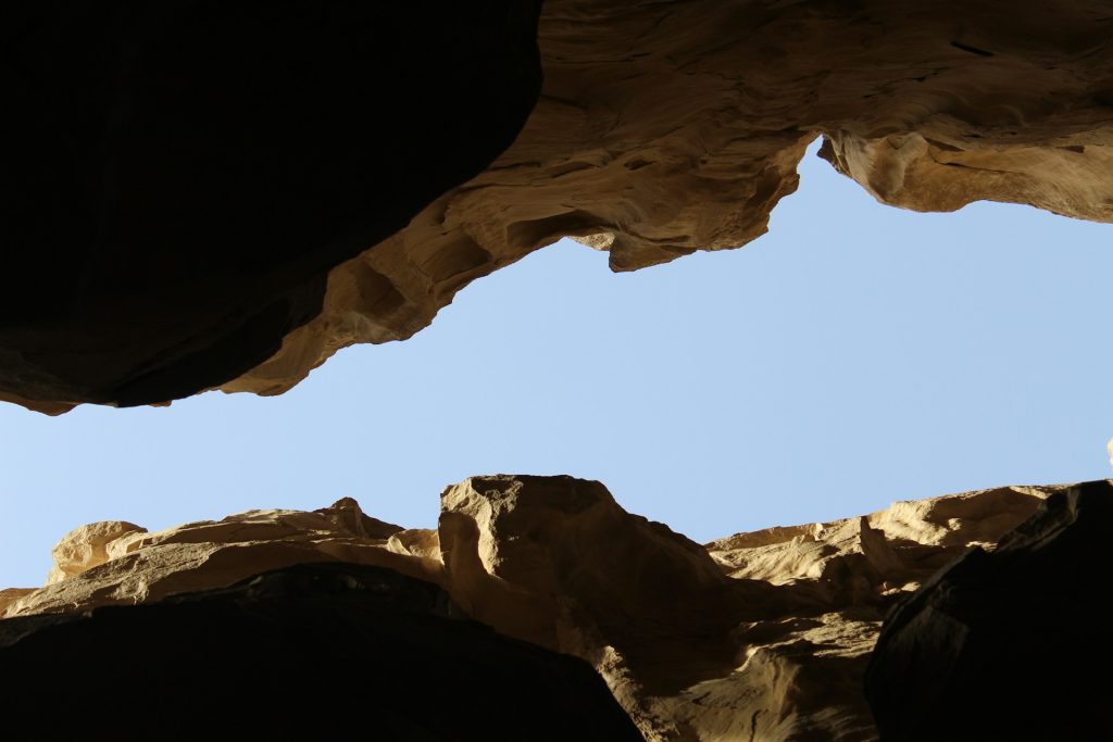 Looking up to the sky from the depths of a chasm with the rock on each side.