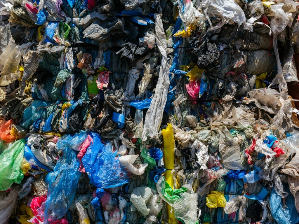 A close-up of a garbage dump with plastics and litter and all manner of disgusting materials piled in a heap.