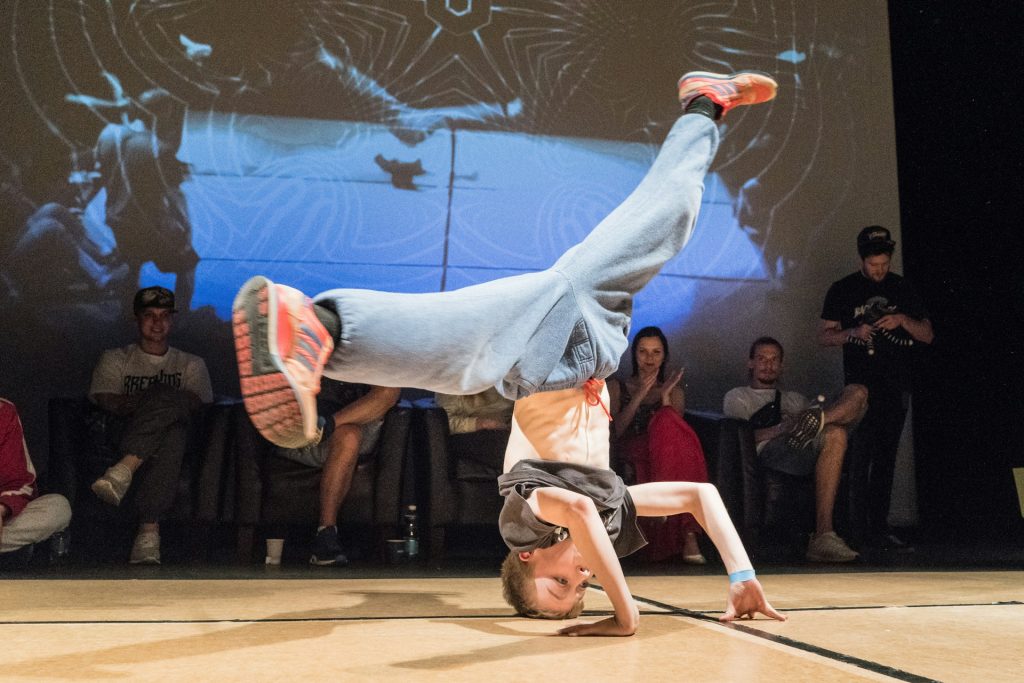 A boy spins on his head in a breakdance move at a Hip-hop event.
