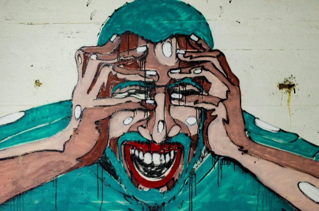 A stylised painting of a person clutching their head and screaming.
