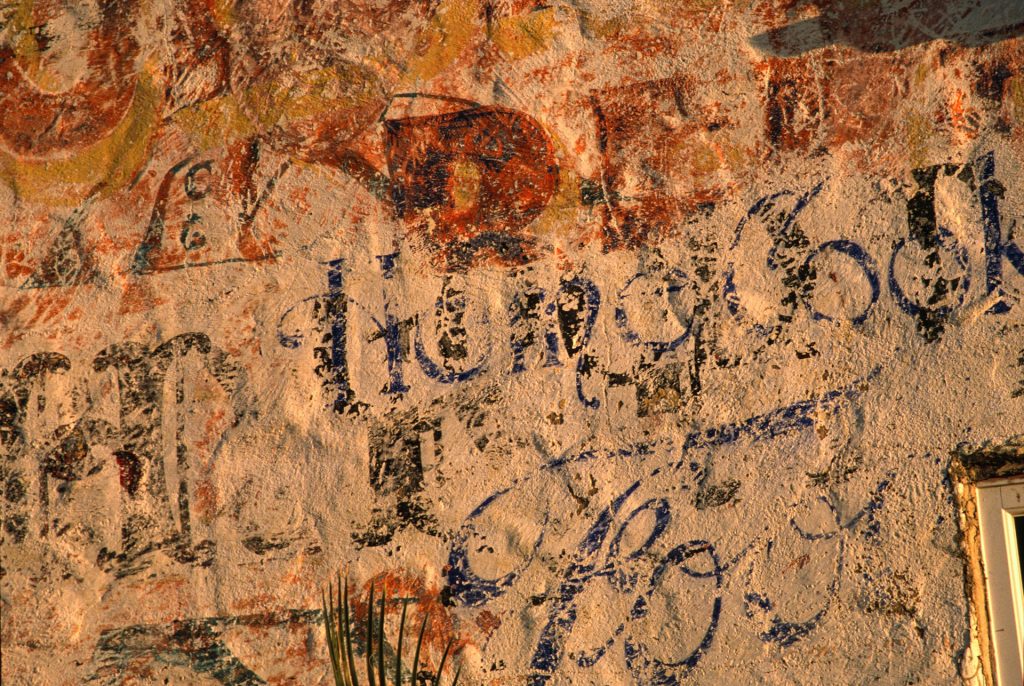 A plaster wall covered in indecipherable writing.