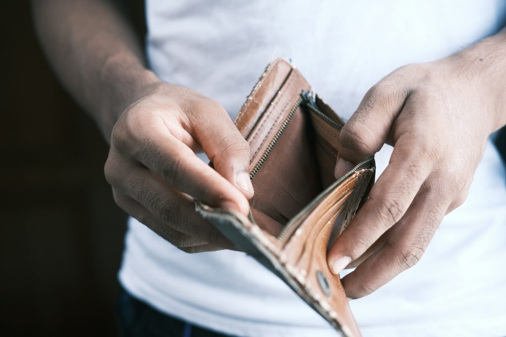 A person opens a brown leather wallet.