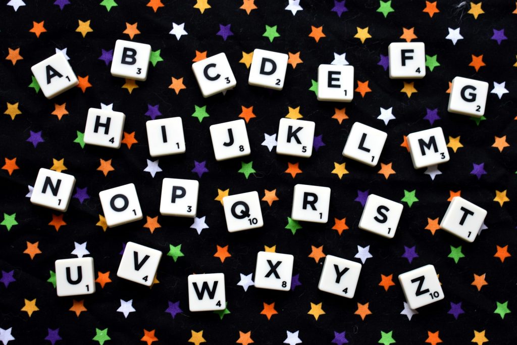 Scrabble tiles laid out in the order of the alphabet, interspersed with colourful stars.