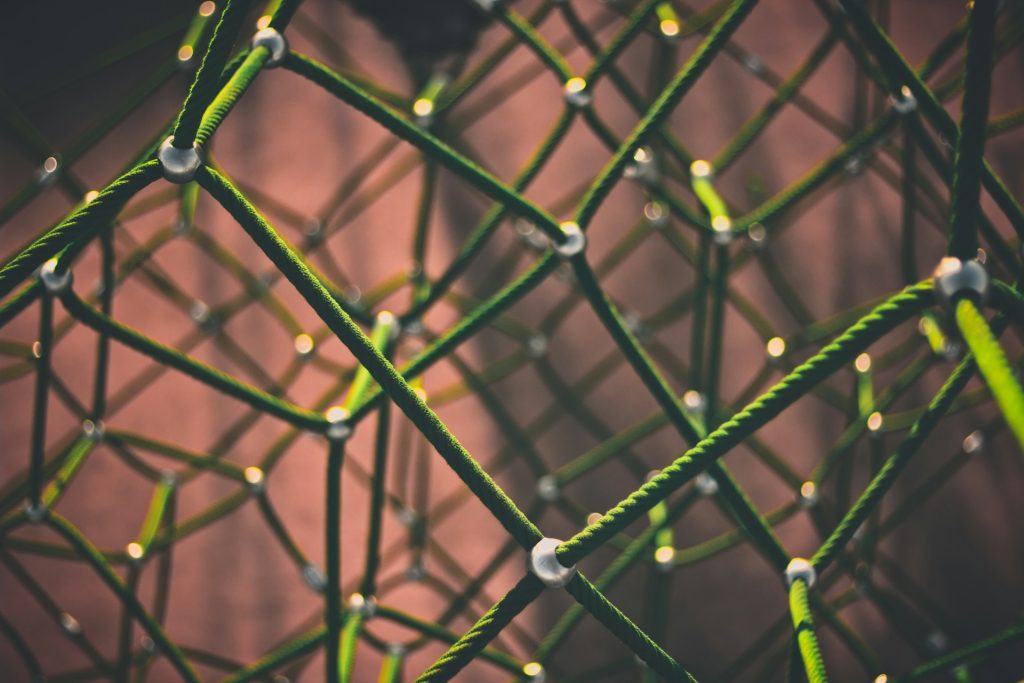 A network of green cords interconnected to white dots in a three dimensional space.