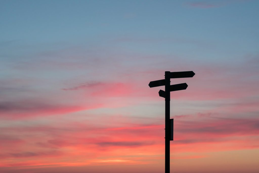 From what and to where did Jesus call his disciples? A signpost is silhouetted against the reds, oranges, and blues of an evening sky.